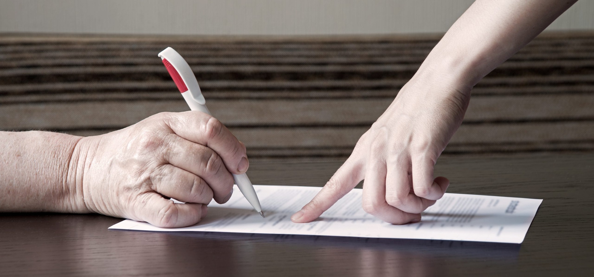 Hands signing a document