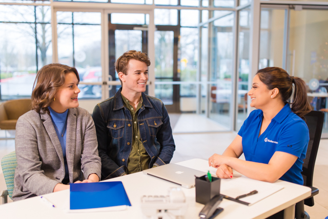 Customers sitting with a bank employee