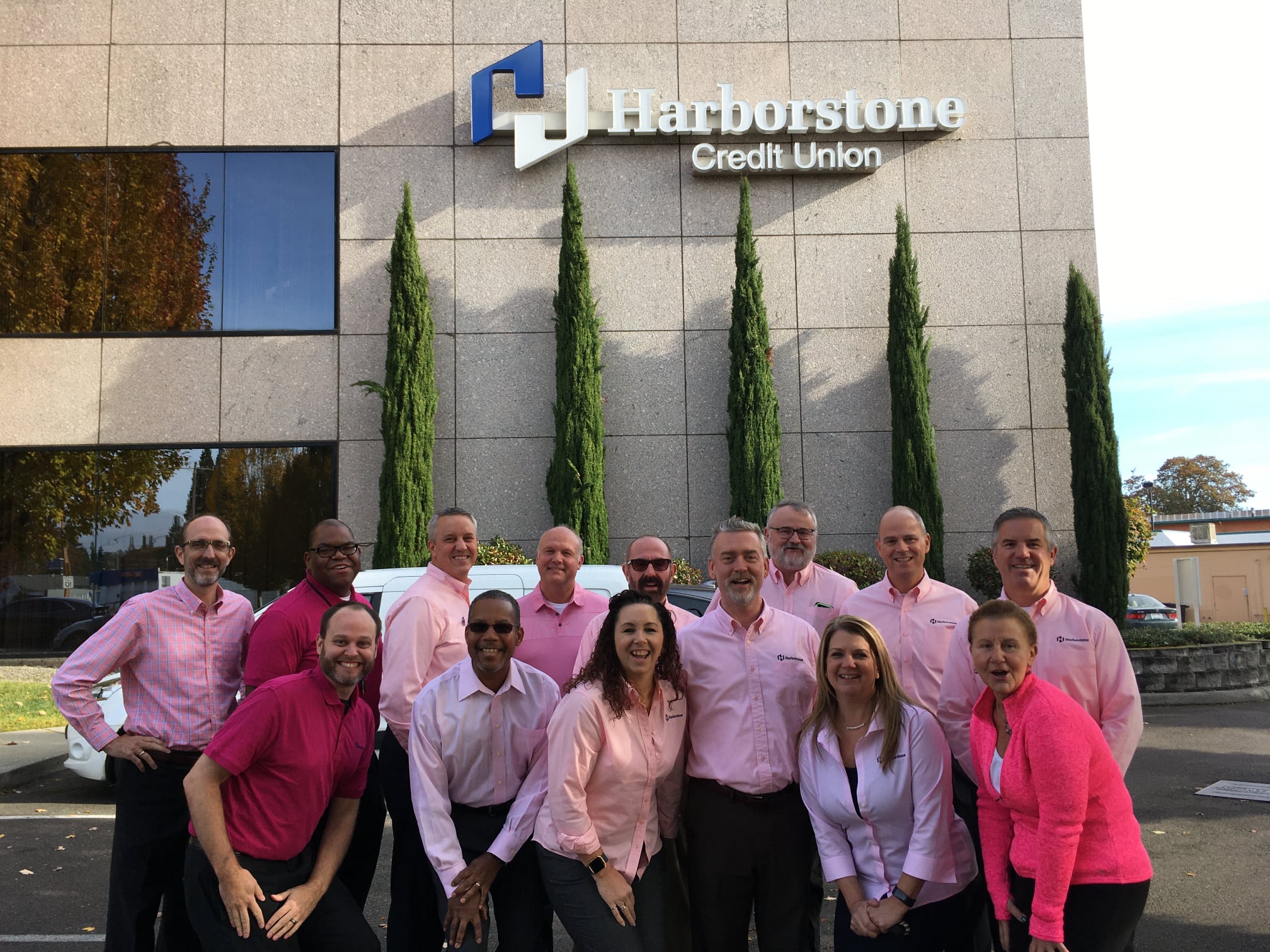 Group of coworkers posing in front of the office building