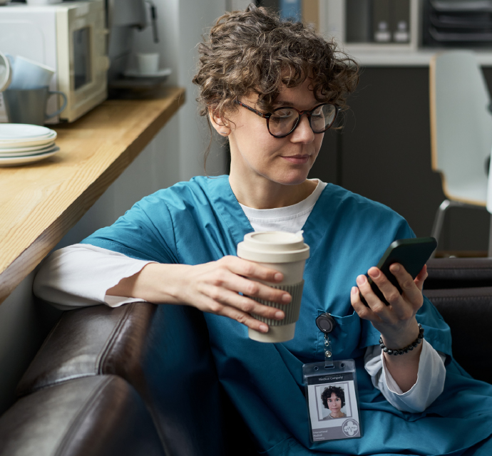 Doctor drinking a coffee and looking at her phone