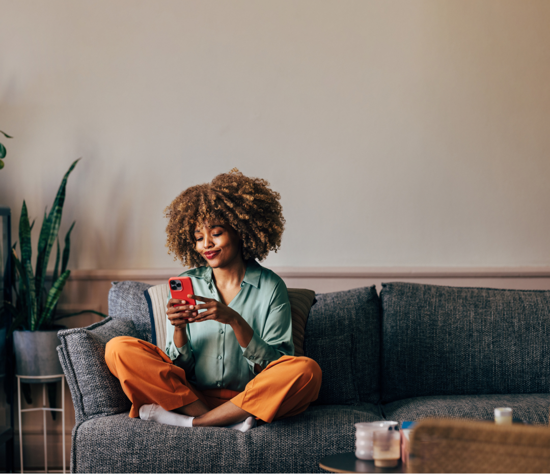 Woman sitting on the couch holding a cell phone
