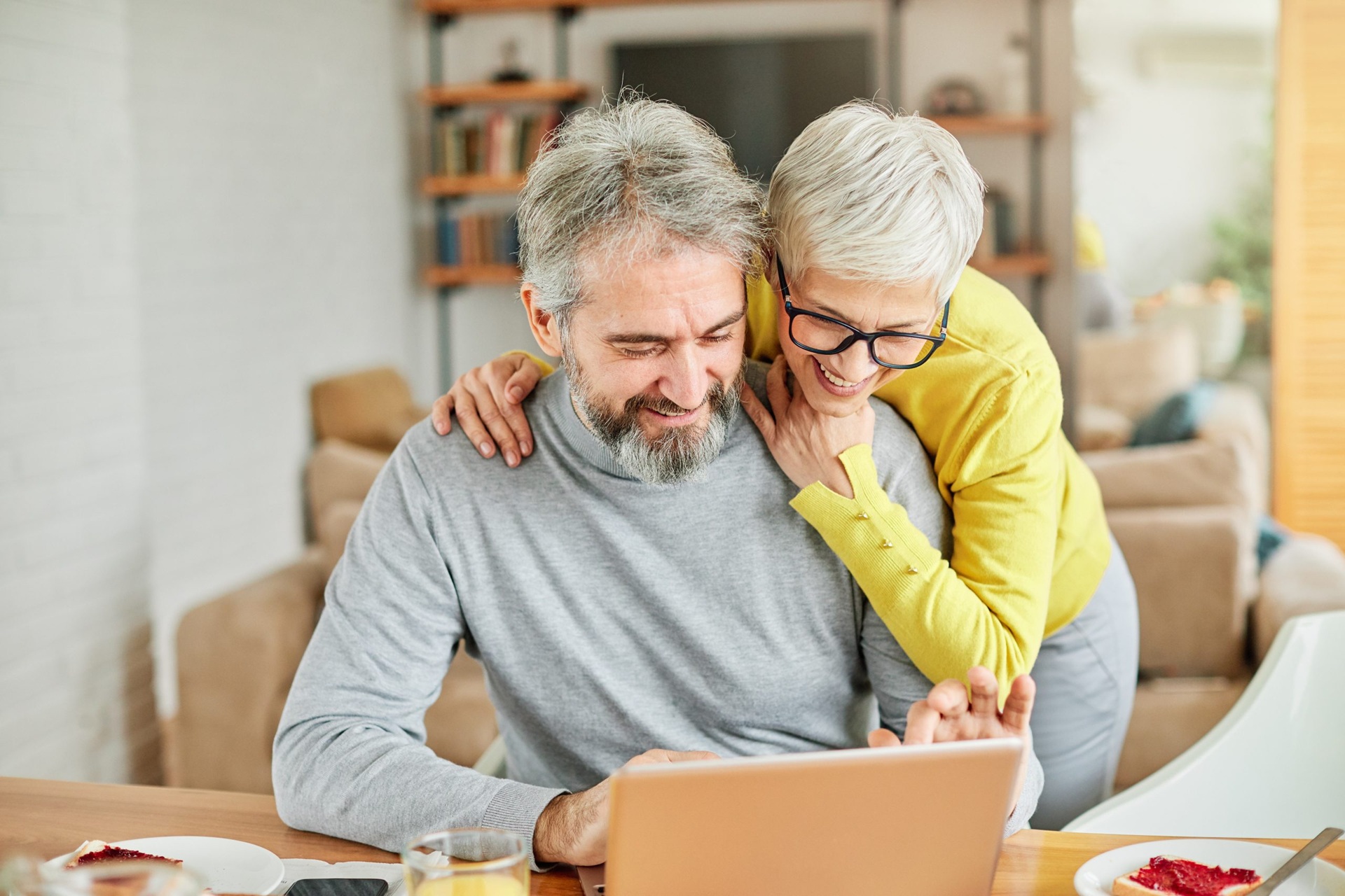 Older couple smiling at a laptop